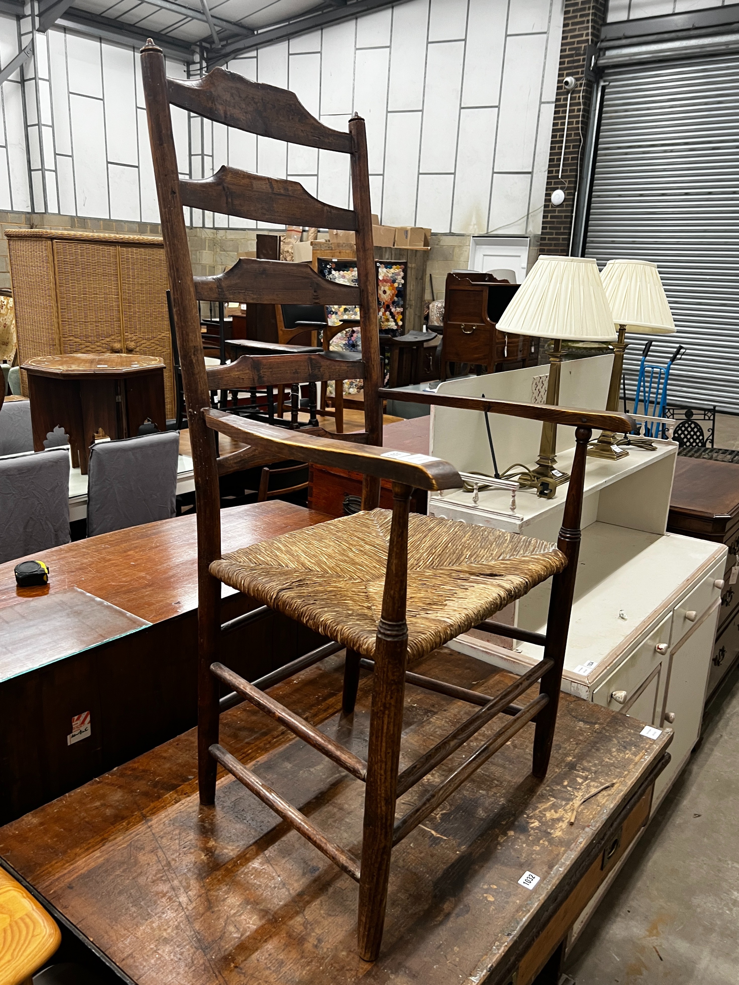 A 19th century provincial ash and elm rush seat ladder back elbow chair, width 59cm, depth 40cm, height 116cm